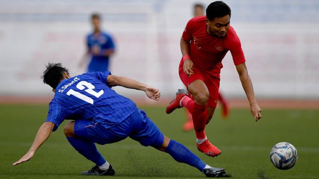 Pemain Timnas U-22 Indonesia Saddil Ramdani (kanan) menggiring bola melewati pemain Timnas Thailand Srayut Sompin dalam pertandingan Grup B SEA Games 2019 di Stadion Rizal Memorial, Manila, Filipina, Selasa (26/11). [ANTARA FOTO/Sigid Kurniawan]
