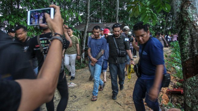 Petugas Direktorat Reserse Narkoba Polda Riau membawa dua orang pelaku pembuat narkoba ketika menggerebek sebuah rumah yang dijadikan tempat pembuatan narkoba jenis pil Happy FIve (H5) di Pekanbaru, Riau, Rabu (27/11). [ANTARA FOTO/Rony Muharrman]