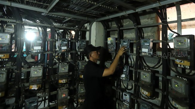 Petugas memeriksa meteran listrik di Rumah Susun Benhil, Jakarta Pusat, Kamis (28/11). [Suara.com/Angga Budhiyanto]
