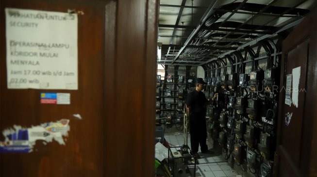 Petugas memeriksa meteran listrik di Rumah Susun Benhil, Jakarta Pusat, Kamis (28/11). [Suara.com/Angga Budhiyanto]
