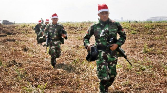 Prajurit TNI berlari seusai melakukan terjun statis saat kunjungan Panglima TNI Marsekal TNI Hadi Tjahjanto beserta rombongan di Timika, Papua, Jumat (29/11). [ANTARA FOTO/Sevianto Pakiding]