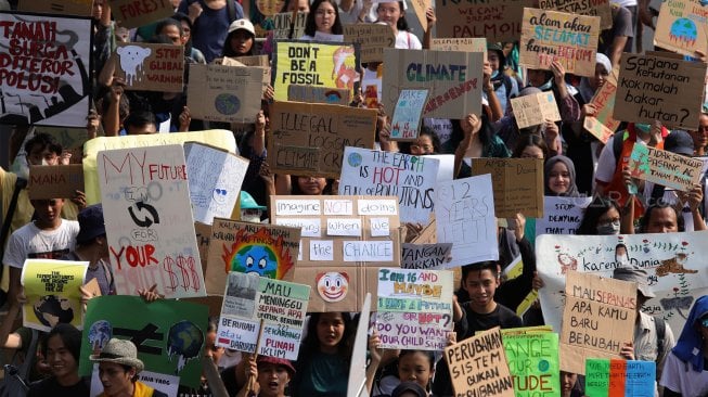 Massa yang tergabung dari Jaringan Jeda Iklim bersama Wahana Lingkungan Hidup (Walhi) melakukan aksi longmarch menuju Taman Aspirasi, Jakarta, Jumat (29/11). [Suara.com/Angga Budhiyanto]