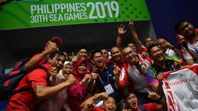 Ketua Umum Komite Olimpiade Indonesia Raja Sapta Oktohari (tengah) bersama Timnas polo air putra melakukan selebrasi seusai dipastikan meraih medali emas SEA Games 2019 di New Clark City Aquatic Center, Filipina, Jumat (29/11). [Antara/Sigid Kurniawan]