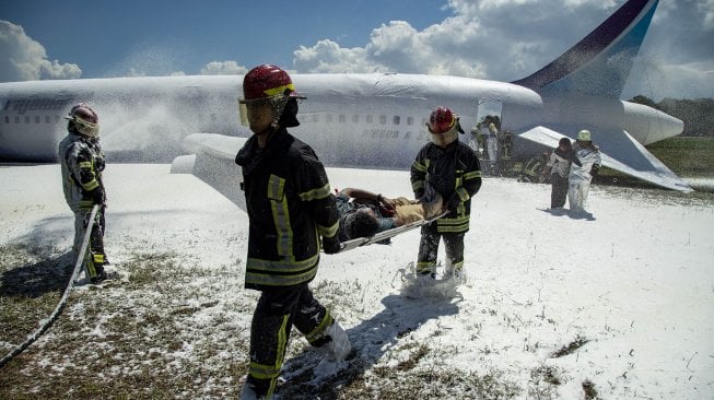 Personel pemadam kebakaran mengevakuasi korban saat simulasi penanganan kecelakaan pesawat di Bandara Hang Nadim Batam, Kepulauan Riau, Kamis (28/11). [ANTARA FOTO/M N Kanwa]