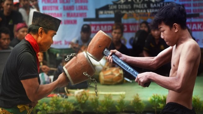 Dua pesilat memeragakan atraksi pukul palu saat Festival Silat Nusantara di Walantaka, Serang, Banten, Sabtu (30/11). [ANTARA FOTO/Asep Fathulrahman]