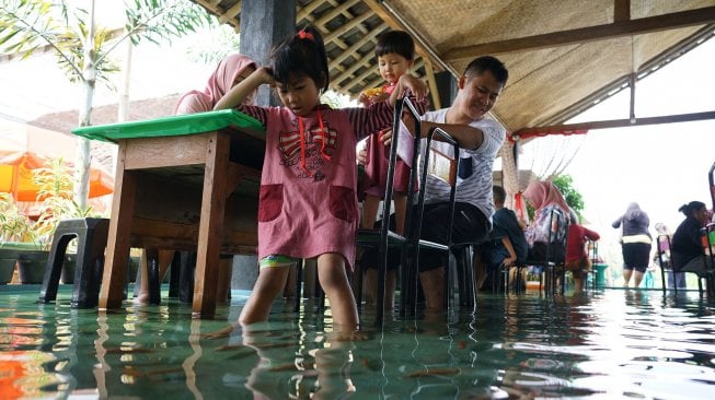 Pengunjung menikmati suasana warung makan yang berada di dalam kolam ikan di Sawahan Lor, Wedomartani, Ngemplak, Sleman, DI Yogyakarta, Sabtu (30/11). [ANTARA FOTO/Hendra Nurdiyansyah]