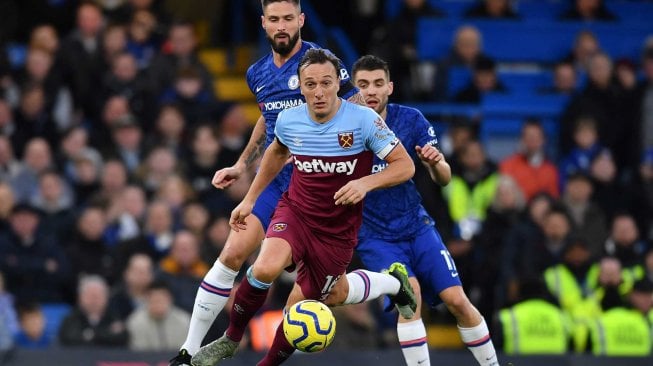 Striker Chelsea asal Prancis Olivier Giroud (kiri) bersaing dengan gelandang Inggris West Ham United Mark Noble selama pertandingan sepak bola Liga Premier Inggris antara Chelsea dan West Ham United di Stamford Bridge di London pada 30 November 2019. [Ben STANSALL / AFP]