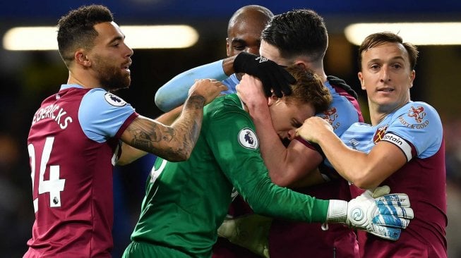 Kiper West Ham United, David Martin merayakan kemenangan dengan rekan satu tim pada peluit akhir saat pertandingan sepak bola Liga Premier Inggris antara Chelsea melawan West Ham United di Stamford Bridge, London, Inggris, Sabtu (30/11) [Ben STANSALL / AFP]
