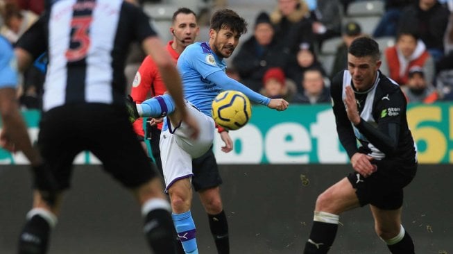 Gelandang Manchester City David Silva (C) melakukan tembakan selama pertandingan sepak bola Liga Inggris antara Newcastle melawan Manchester City di St James 'Park, Newcastle-upon-Tyne, Inggris, Sabtu (30/11). [Lindsey Parnaby / AFP]