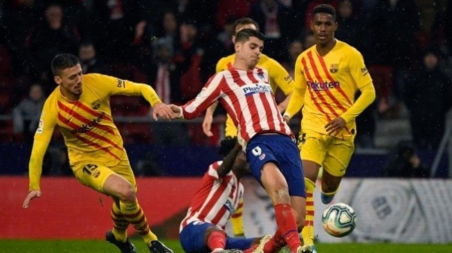 Striker Atletico Madrid Alvaro Morata berebut bola dengan para pemain Barcelona di ajang Liga Spanyol di Wanda Metropolitano Stadium, Senin (2/12) dini hari WIB. (Foto: AFP)