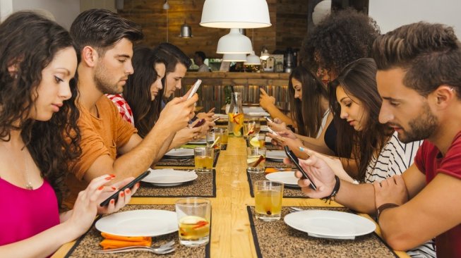 Ilustrasi para remaja yang fokus dengan ponsel pintar mereka masing-masing. [Shutterstock]