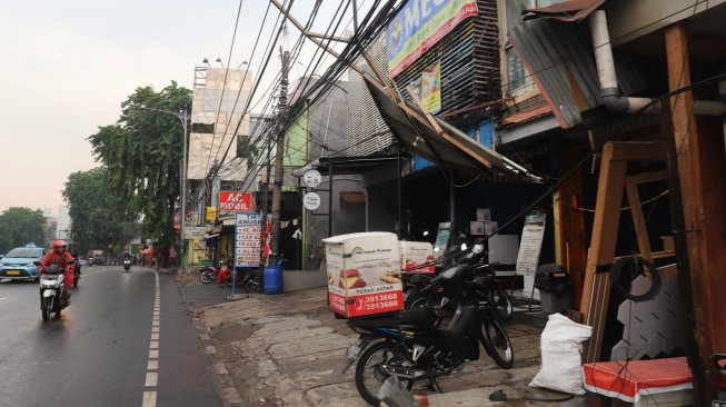 Suasana pasca robohnya papan reklame di Jalan Warung Buncit Raya, Jakarta, Senin (2/12). [Suara.com/Alfian Winanto]