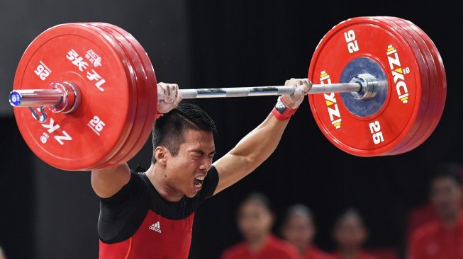 Lifter Indonesia Deni mengangkat beban dalam pertandingan angkat besi kelas 67 kg putra SEA Games 2019 di Stadion RSMC Nino Aquino, Manila, Filipina, Selasa (3/12). [Antara/Nyoman Budhiana]