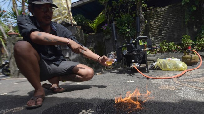 Warga Tabanan, I Gusti Ngurah Adnyana menunjukkan bahan bakar yang dihasilkan dari mesin pengolahan sampah plastik hasil karyanya.