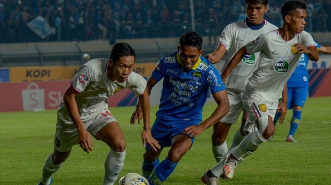 Persib Bandung footballer, Frets Butuan (second left) fights for the ball with Persela Lamongan footballer, Ahmad Birrul (left) in the 2019 League 1 match at Si Jalak Harupat Stadium, Bandung, Tuesday (3/12/2019) evening WIB.  (ANTARA PHOTOS/Raisan Al Farisi)