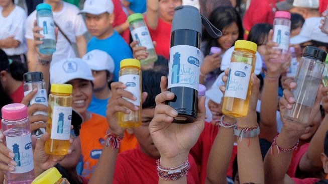 Warga menunjukkan tumbler atau botol minuman dalam acara Indonesia Bersih Melalui Gerakan Satu Juta Tumbler di kawasan Pantai Matahari Terbit Sanur.