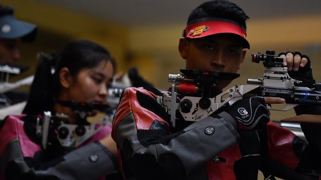 Atlet menembak Indonesia Fathur Gustafian (kanan) dan Vidya Rafika Rahmatan Toyyiba mengikuti kualifikasi 10 meter Air Rifle Mixed Team SEA Games 2019 di Philippine Marine Shooting Range Total, Manila, Filipina, Kamis (5/12). [Antara/Sigid Kurniawan]