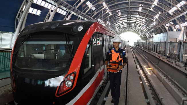 Petugas melintasi gerbong kereta 'light rail train' atau lintas rel terpadu (LRT) di Stasiun Harjamukti, Cimanggis, Kota Depok, Jawa Barat, Rabu (4/12). [ANTARA FOTO/Aditya Pradana Putra]