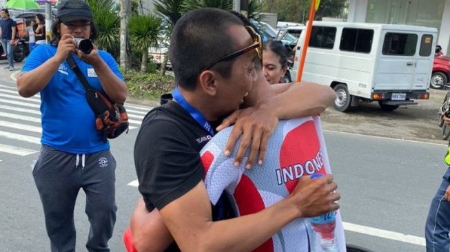 Pelatih timnas Indonesia Rastra Patria Dinawan (kiri) memeluk Aiman Cahyadi setelah merebut emas pertama balap sepeda di SEA Games 2019, Kamis (5/12). [Dok. Tim CdM Indonesia]
