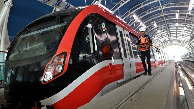 Petugas melintasi gerbong kereta 'light rail train' atau lintas rel terpadu (LRT) di Stasiun Harjamukti, Cimanggis, Kota Depok, Jawa Barat, Rabu (4/12). [ANTARA FOTO/Aditya Pradana Putra]