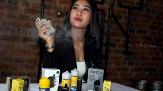 Model menghisap rokok elektrik disela acara Resolusi 2020 'I Choose to be Healthier' Rabu (4/12). [Suara.com/Oke Atmaja]