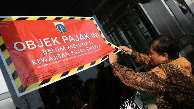 Petugas Badan Pajak dan Restribusi Daerah (BPRD) DKI Jakarta menempelkan stiker 'Objek Pajak' saat Supervisi pencegahan pajak di Mall Baywalk, Pluit, Jakarta Utara di Jakarta, Kamis (5/12). [ANTARA FOTO/M Risyal Hidayat]