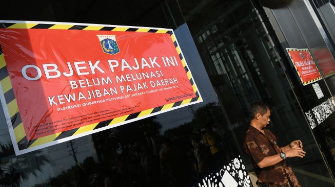 Petugas Badan Pajak dan Restribusi Daerah (BPRD) DKI Jakarta melintas di antara stiker 'Objek Pajak' saat Supervisi pencegahan pajak di Mall Baywalk, Pluit, Jakarta Utara di Jakarta, Kamis (5/12). [ANTARA FOTO/M Risyal Hidayat]