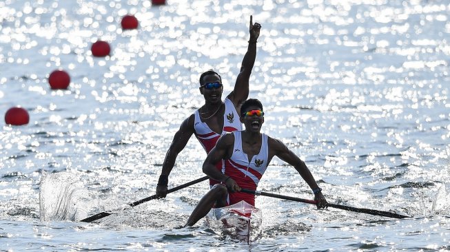 Atlet dayung Indonesia Anwar Tarra (kiri) dan Yuda Firmansyah melakukan selebrasi seusai memasuki garis finis dalam final kano 1000 meter double putra SEA Games 2019 di Malawaan Park, Filipina, Jumat (6/12). [Antara/Sigid Kurniawan]