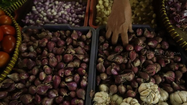 Pedagang merapikan bawang merah di Pasar Minggu, Jakarta Selatan, Jumat (6/12). [Suara.com/Angga Budhiyanto]