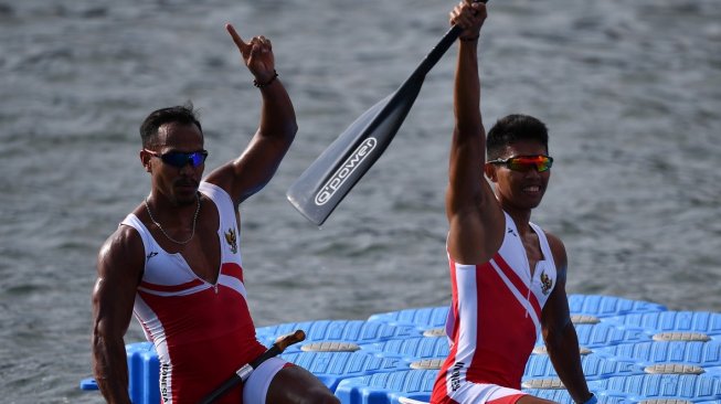 Atlet dayung Indonesia Anwar Tarra (kiri) dan Yuda Firmansyah melakukan selebrasi seusai memasuki garis finis dalam final kano 1000 meter double putra SEA Games 2019 di Malawaan Park, Filipina, Jumat (6/12). [Antara/Sigid Kurniawan]