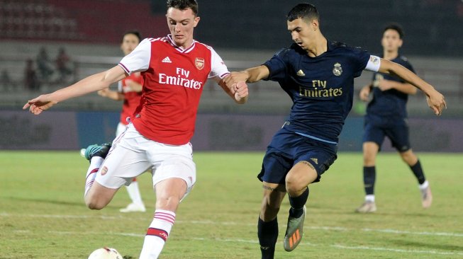 Pesepak bola Real Madrid U-18 Javier Rodriguez Lancho (kanan) berebut bola dengan pesepak bola Arsenal U-18 Alexander Kirk (kiri) saat pertandingan U-20 International Cup 2019 di Stadion Kapten I Wayan Dipta, Gianyar, Bali, Kamis (5/12). [ANTARA FOTO/Fikri Yusuf]