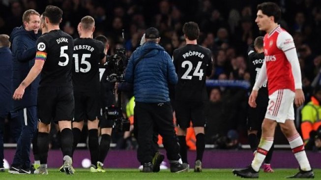 Manajer Brighton Graham Potter (kiri)  memberikan selamat kepada para pemainnya setelah mengalahkan Arsenal 2-1 dalam laga Liga Inggris di Emirates Stadium. Ben STANSALL / AFP