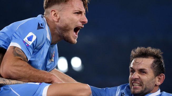 Pemain depan Italia asal Italia Ciro Immobile (kiri) merayakan golnya selama pertandingan sepak bola Serie A Italia, Lazio melawan Juventus di stadion Olimpico, Roma, Italia, Minggu (8/12) dini hari WIB. [Filippo MONTEFORTE / AFP]
