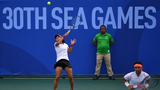 Petenis ganda campuran Indonesia Aldila Sutjiadi (kiri) yang berpasangan dengan Christopher Rungkat mengembalikan bola ke arah ganda campuran Thailand Sanchai Ratiwatana dan Tamarine Tanasugarn dalam babak final ganda campuran SEA Games 2019 di lapangan Rizal Memorial Tennis Center, Manila, Filipina, Sabtu (7/12). [ANTARA FOTO/Sigid Kurniawan]