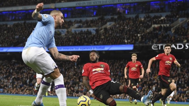 Gelandang Manchester United Fred memblokir umpan silang dari bek Manchester City Kyle Walker  selama pertandingan sepak bola Liga Inggris antara Manchester City melawan Manchester United di Stadion Etihad, Manchester, Inggris, Sabtu (7/12). [Oli SCARFF / AFP]
