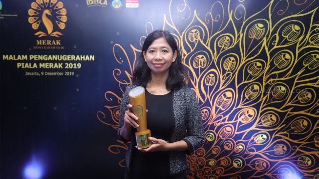 Asisten Redaktur Pelaksana sekaligus perwakilan dari Suara.com, Ririn Indriani berfoto usai menerima piala penghargaan Piala Merak 2019 saat Malam Penganugerahan Piala Merak 2019 di Wisma Antara, Jakarta Pusat, Senin (9/12). [Suara.com/Angga Budhiyanto]