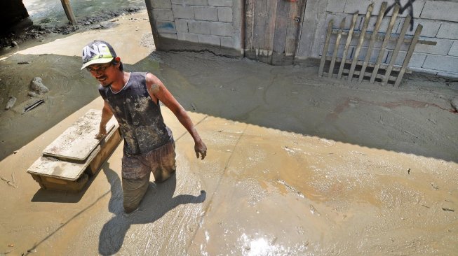 Warga berada disekitar rumah yang rusak dan terendam lumpur akibat diterjang banjir bandang di Desa Poi, Kabupaten Sigi, Sulawesi Tengah, Minggu (8/12).[ANTARA FOTO/Mohamad Hamzah]
