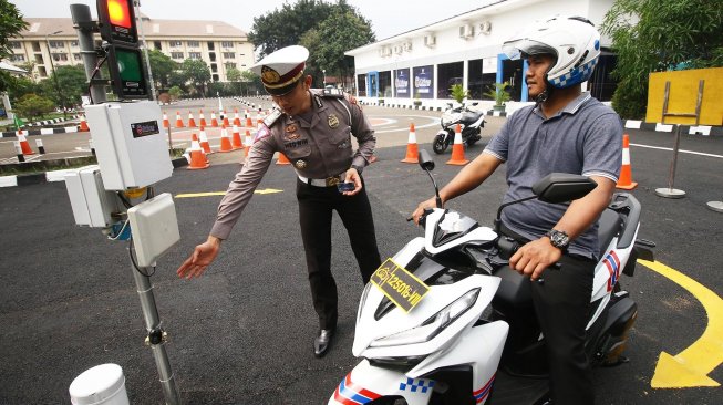 Kepala Seksi SIM Subdit Regident Ditlantas Polda Metro Jaya AKP Lalu Hedwin (kiri) menjelaskan cara mengikuti uji praktik SIM sistem elektronik di Satuan Penyelenggara Administrasi (Satpas) SIM Daan Mogot, Jakarta, Selasa (10/12). [ANTARA FOTO/Rivan Awal Lingga]
