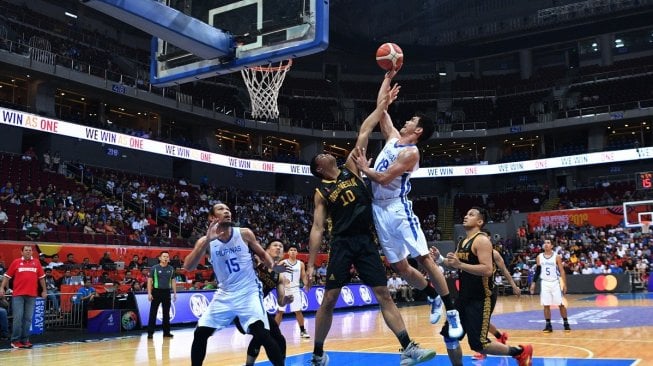 Pebasket Indonesia Kevin Sitorus (kedua kiri) mencoba memblok bola dari pebasket Filipina Jeth Roy Rosario (kedua kanan) dalam pertandingan babak semifinal basket putra SEA Games 2019 di SM Mall of Asia Arena, Manila, Filipina, Senin (9/12). [Antara/Sigid Kurniawan]