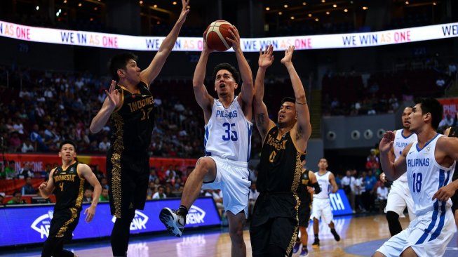 Pebasket Indonesia Mei Joni (kedua kiri) dan Juan Laurent (kedua kanan) mencoba merebut bola dari pebasket Filipina Matthew Wright (tengah) dalam pertandingan babak semifinal basket putra SEA Games 2019 di SM Mall of Asia Arena, Manila, Filipina, Senin (9/12). [Antara/Sigid Kurniawan]