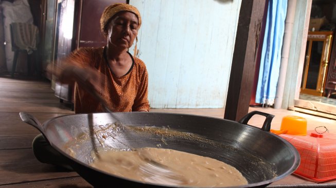 Sukenah (54) salah satu pengerajin susu kerbau rawa di Desa Kuro, saat mengola susu kerbau menjadi gula puan Sabtu (10/05/2019). Gula puan salah satu olahan berbahan baku susu kerbau yang bernilai ekonomi tinggi, yang masih menjadi penghasilan tambahan. [Foto: Ibrahim Arsyad]