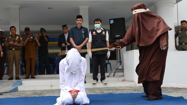 Terpidana pelanggar hukum Syariat Islam (kiri) menjalani eksekusi cambuk di Taman Sari, Banda Aceh, Selasa (10/12). [ANTARA FOTO/Ampelsa]