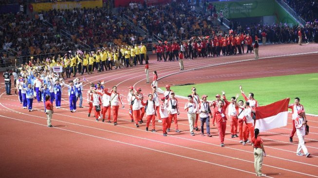 Kontingen Indonesia berparade bersama kontingen 10 negara lainnya dalam upacara penutupan SEA Games 2019 di Stadion Atletik New Clark, Filipina, Rabu (11/12). [AFP/Ted Aljibe]