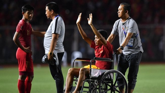 Pemain Timnas U-22 Indonesia Evan Dimas yang cedera menyapa suporter seusai Timnas Indonesia kalah dari Timnas Vietnam dalam final sepak bola putra SEA Games 2019 di Stadion Rizal Memorial, Manila, Filipina, Selasa (10/12).  [ANTARA FOTO/Sigid Kurniawan]