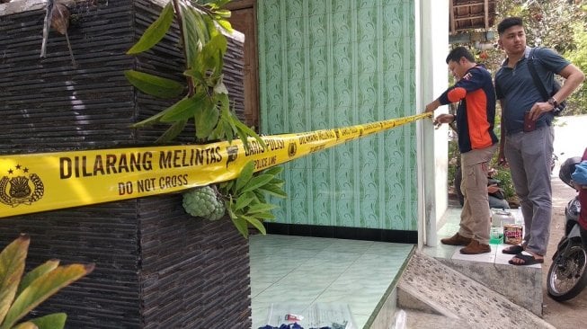 Sejumlah petugas dari Polres Sleman dan Polda DIY tengah memasang garis polisi di lokasi bom molotov di Dusun Pasikan Kidul, Desa Balecatur, Kecamatan Gamping, Kabupaten Sleman, DI Yogyakarta, Rabu (11/12/2019). - (SUARA/Baktora)