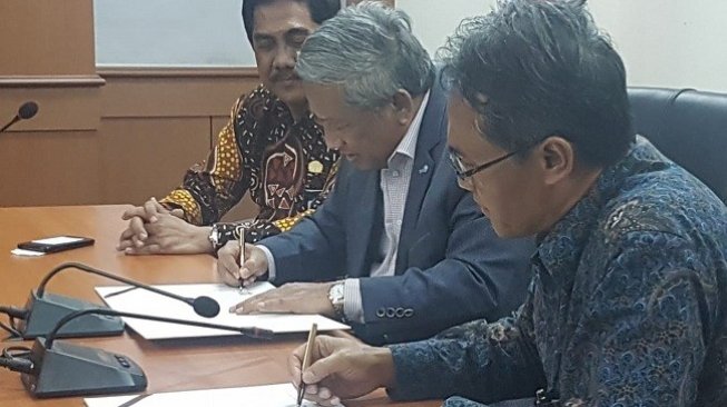 Rektor UGM Panut Mulyono (kanan) dan Ketua Dewan Pers, M. Nuh (tengah) menandatangani nota kesepahaman sebagai bentuk kerjasama antara UGM dengan Dewan Pers. (Foto: Humas UGM)