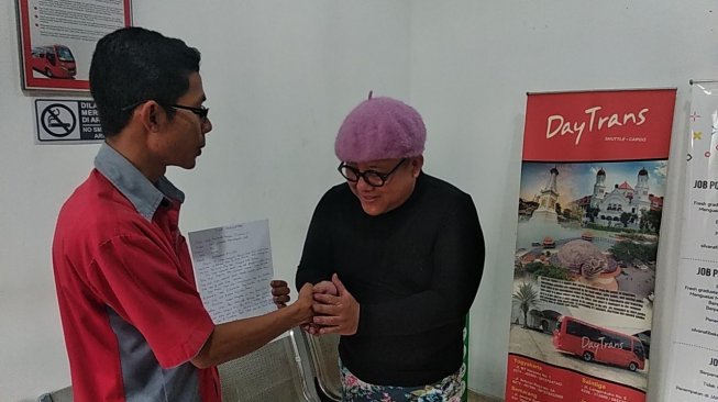Seorang pengemudi mobil mewah, JS (bertopi ungu) dan Pengemudi Travel Daytrans, Hunggul Budi Prihono (paling kanan) berdamai ketika ditemui di kantor Daytrans, Kota Yogyakarta, Kamis (12/12/2019). [Muhammad Ilham Baktora / SuaraJogja.id]
