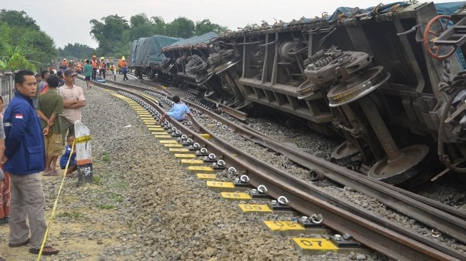 Petugas memeriksa kondisi anjloknya Kereta Api barang 2704 pengangkut semen yang melaju dari stasiun Kampung Bandan menuju stasiun Kalimas di KM 52+926 di jalur stasiun Doplang, Blora, Jawa Tengah (12/12). [ANTARA FOTO/Yusuf Nugroho]