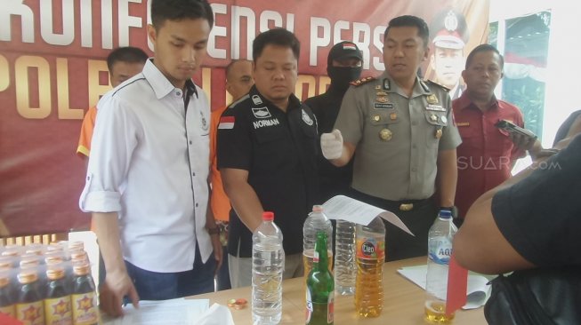 Polisi mengumumkan konferensi pers tentang dua tersangka Muhammad Soeharto (54) penjual miras oplosan dan Suwandi (56) pemasok miras oplosan di Polres Lamongan, Jumat (13/12/2019) [Suara.com/Tofan Kumara].