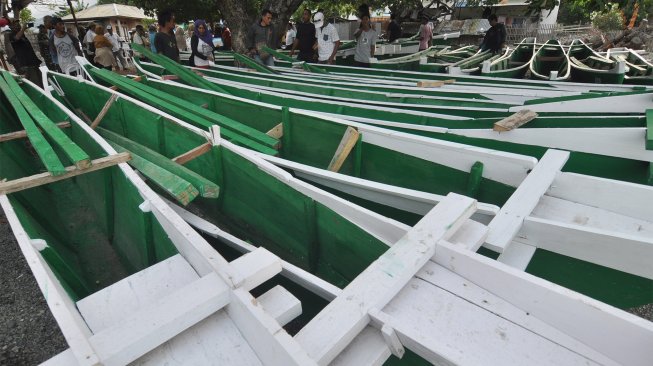 Nelayan mengamati perahu bantuan yang akan dibagikan kepada mereka di Kelurahan Tipo, Kecamatan Ulujadi, Palu, Sulawesi Tengah, Sabtu (14/12). [ANTARA FOTO/Mohamad Hamzah]